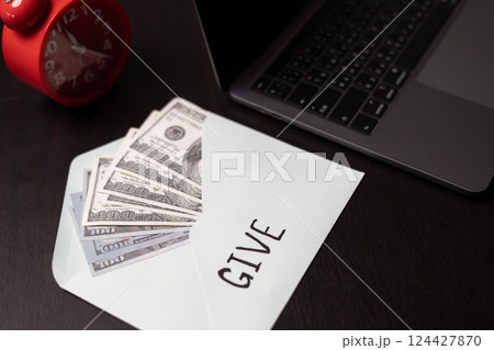 Woman held jar filled with cash with words in bold lettering urging people to donate money, extending her hand in gesture of giving part of her business's charitable efforts. 124427870
