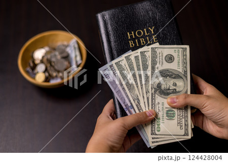 She felt deep sense of fulfillment when donating money to church, placing her tithe of coins and cash into offering bowl, knowing her giving would help fund important causes. donating, money, tithe. 124428004