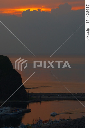 沈みゆく夕陽の中を港へ帰る船（斜里町） 124428417