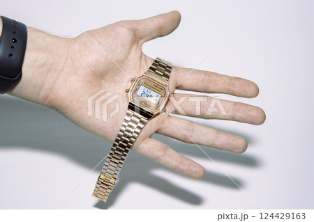 Golden watch with electronic dial on human palm. Golden watch with electronic dial on human palm. 124429163
