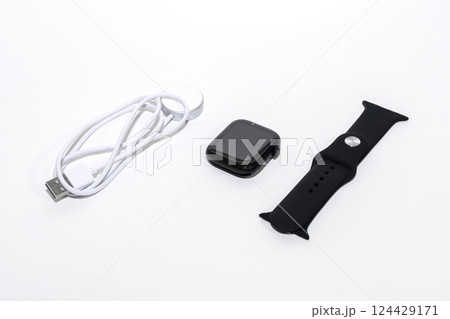 Black smart watch bracelet and charger on white background. Black smart watch bracelet and charger on white background. 124429171
