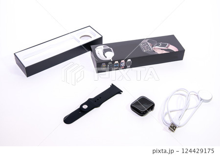 Black smart watch bracelet and charger on white background. 124429175