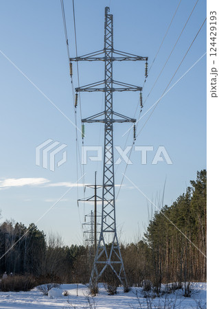 Tall power lines against the blue sky in the forest. Tall power lines against the blue sky in the forest. 124429193