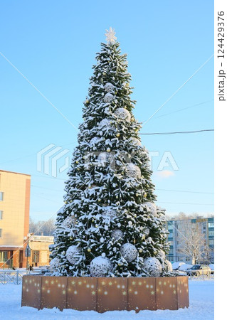 A beautifully snowcovered Christmas tree standing majestically in a winter wonderland 124429376