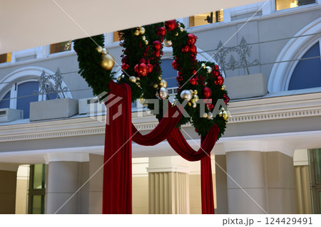 Experience Elegant Christmas Decor featuring Beautiful Wreaths and Striking Red Drapes 124429491