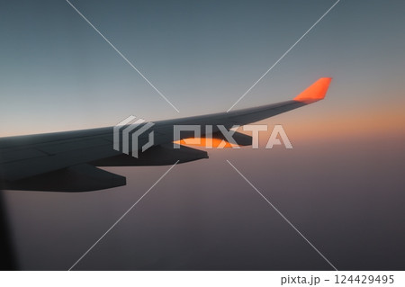 A Beautiful and Scenic View from an Airplane Wing During a Majestic Sunset in the Sky 124429495