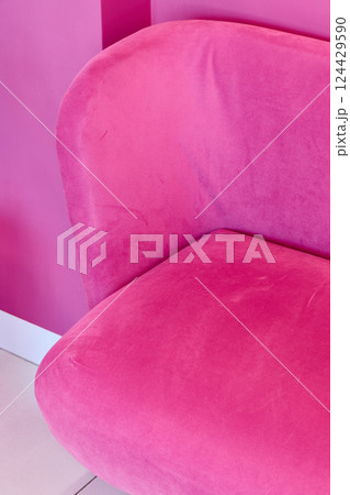 A Vibrant Pink Upholstered Chair Positioned Beautifully Against a Bold Pink Wall Background A Vibrant Pink Upholstered Chair Positioned Beautifully Against a Bold Pink Wall Background 124429590