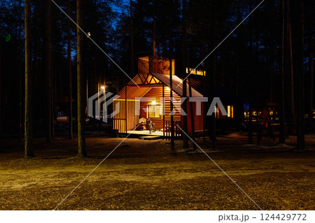A Cozy Cabin That Is Beautifully Illuminated by Night in a Serene Forest Setting 124429772