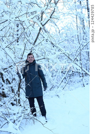 A person stands peacefully in a stunning snowy winter wonderland filled with tranquility 124429785