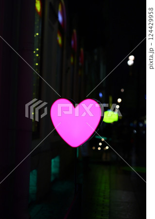 A Neon Heart Sign Illuminated at Night in a Vibrant City Scene Filled with Life and Color A Neon Heart Sign Illuminated at Night in a Vibrant City Scene Filled with Life and Color 124429958