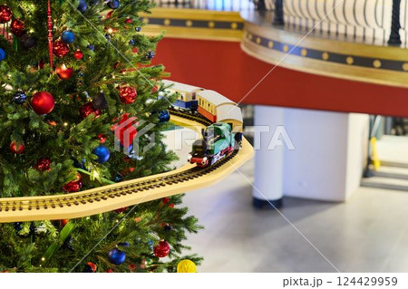 A Festive Christmas Tree beautifully adorned with delightful Train Decoration for the season A Festive Christmas Tree beautifully adorned with delightful Train Decoration for the season 124429959