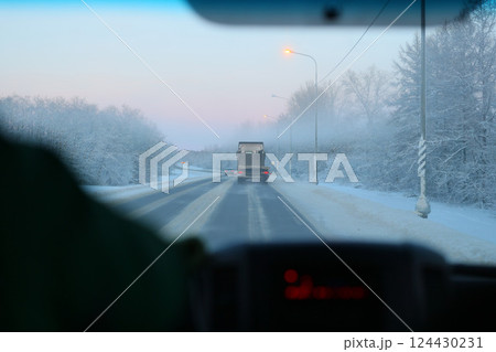 Experience the exhilarating Winter Drive on a Snowy Road with a powerful Cargo Truck 124430231
