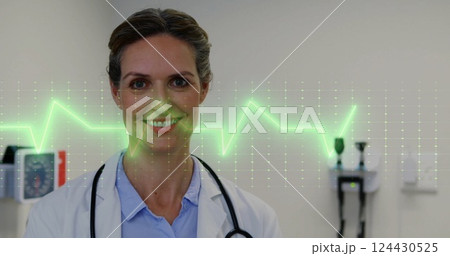 Image of cardiograph over caucasian female doctor smiling in hospital 124430525