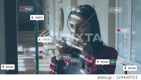 Image of icons and data processing over biracial woman drinking tea Image of icons and data processing over biracial woman drinking tea 124430721