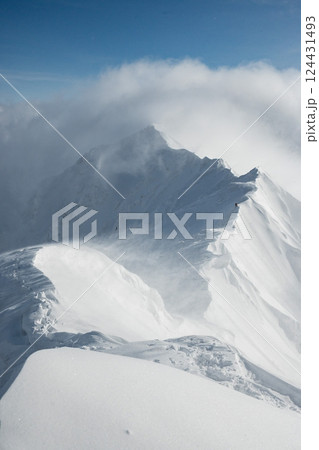 雪煙舞う山肌　険しい稜線の雪山　3月の雪山を登山 124431493