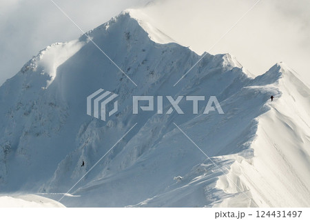 雪煙舞う山肌　険しい稜線の雪山　3月の雪山を登山 124431497