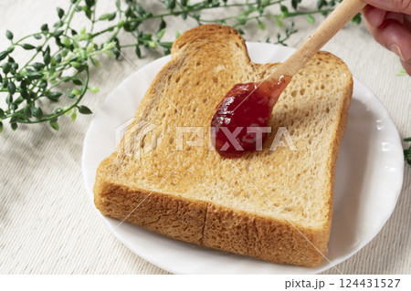 瓶詰めのいちごジャムをトーストした食パンに塗 124431527