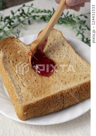 瓶詰めのいちごジャムをトーストした食パンに塗 124431533