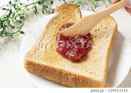 瓶詰めのいちごジャムをトーストした食パンに塗 瓶詰めのいちごジャムをトーストした食パンに塗 124431535