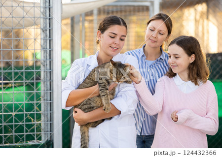 Female animal shelter worker offering gray cat for adoption Female animal shelter worker offering gray cat for adoption 124432366