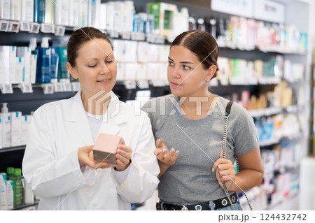 In pharmacy, female buyer of cosmetic department doubts and asks for advice from pharmacist. In pharmacy, female buyer of cosmetic department doubts and asks for advice from pharmacist. 124432742