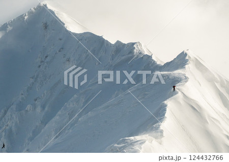 雪煙舞う山肌　険しい稜線の雪山　3月の雪山を登山 124432766