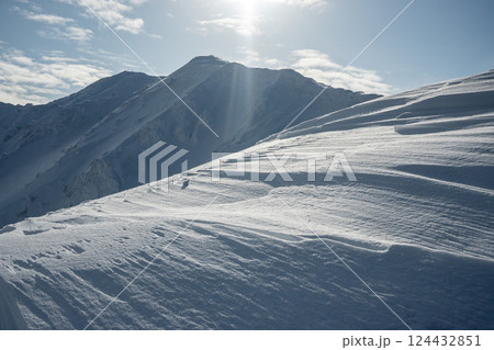 雪煙舞う山肌　険しい稜線の雪山　3月の雪山を登山 124432851