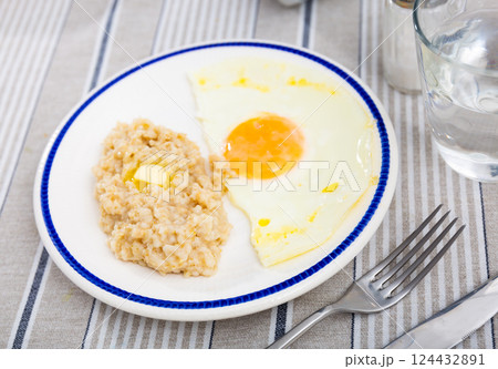 Breakfast with scrambled eggs and oatmeal with butter closeup 124432891
