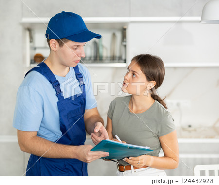 Young technician from cleaning company discussing order with female homeowner 124432928