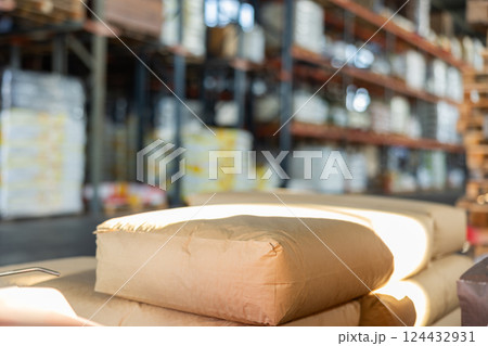 Paper sacks without inscriptions with fertilizers or construction mixtures stacked in warehouse 124432931
