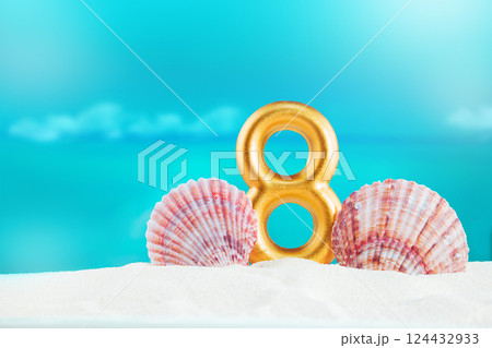 Golden number eight stands on soft white sand, by large pink seashells, against backdrop of calm blue sea on sunny day. Celebration, nature beaut 124432933