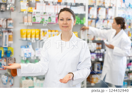 Adult female pharmacist in uniform posing in pharmacy Adult female pharmacist in uniform posing in pharmacy 124432940