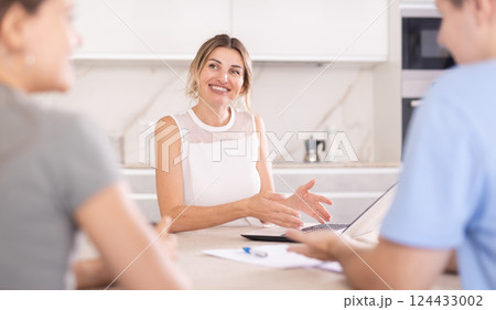Woman manager tells clients about specifics of design of microloan, about benefits and advantages 124433002