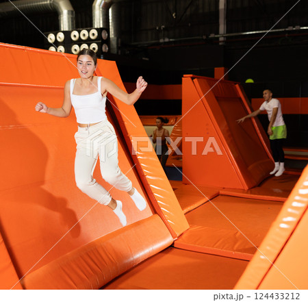 Portrait of sporty girl jumping on trampolines in her free time in gaming club Portrait of sporty girl jumping on trampolines in her free time in gaming club 124433212