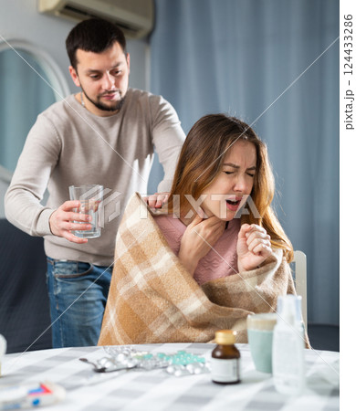 Man carrying glass of water for his wife who got sick with flu Man carrying glass of water for his wife who got sick with flu 124433286