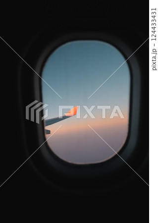 An Aircraft Wing is Captured Against a Beautiful Sunset Through the Passenger Window 124433431