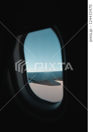 The incredible view from an airplane window showcases the wing and the vast sky beyond The incredible view from an airplane window showcases the wing and the vast sky beyond 124433470