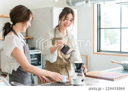 カフェ・コーヒーショップ・喫茶店でコーヒーを淹れるバリスタ・焙煎士の女性スタッフ・マスター 124433864