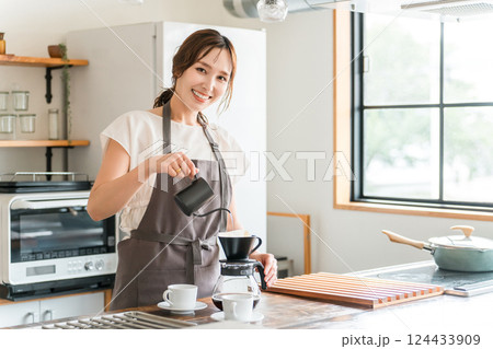 キッチン・カフェでコーヒーをいれる女性 124433909