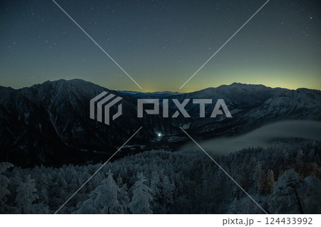 晴天の下、西穂高岳稜線から岐阜県の夜景と北アルプスを眺める　軌跡で見る星空 124433992
