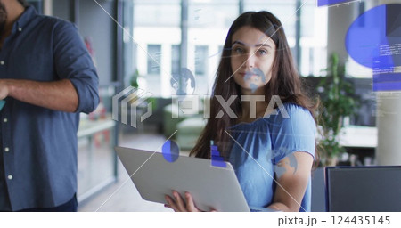 Image of charts processing over happy caucasian businesswoman with laptop at casual office Image of charts processing over happy caucasian businesswoman with laptop at casual office 124435145