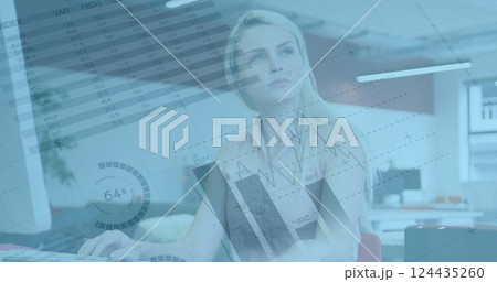 Image of financial data processing over caucasian businesswoman holding documents in office 124435260