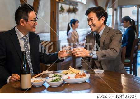 居酒屋・飲み屋で部下と楽しくお酒を飲むビジネスマンの男性 124435627
