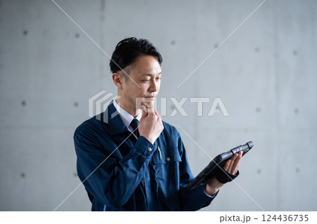 タブレットを見て考える男性 124436735