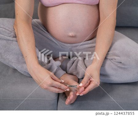 Pregnant woman trying to get herself a pedicure. Pregnant woman trying to get herself a pedicure. 124437855