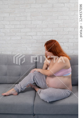 Caucasian pregnant woman suffering from leg cramps. Third trimester. Caucasian pregnant woman suffering from leg cramps. Third trimester. 124437896