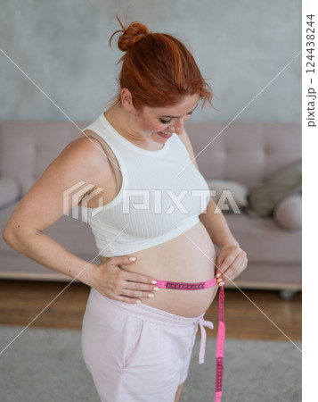 Pregnant woman measuring her belly.  124438244
