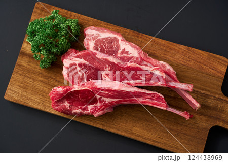 木製まな板に盛り付けた生のラムチョップ肉 124438969