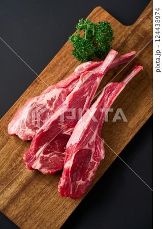 木製まな板に盛り付けた生のラムチョップ肉 木製まな板に盛り付けた生のラムチョップ肉 124438974