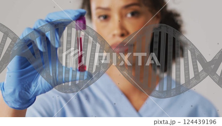 Image of dna strand and biracial female doctor with vial on white background 124439196